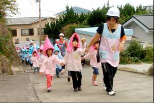 写真：防護頭巾をかぶって訓練する園児たち
