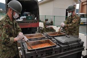 写真：大きな鍋でカレーを作る男性