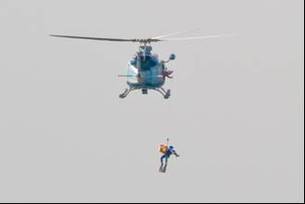 写真：ヘリコプターからのびたワイヤーで救助される様子1