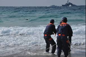 写真：海辺からロープを使って救助訓練する様子