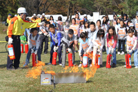 写真：消火器を使って火を消す子供たち