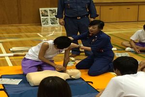 写真：学生に応急手当の訓練をする女子団員