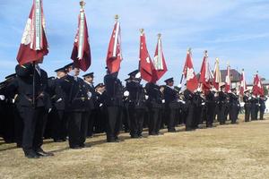 写真：団旗を持つ制服姿の団員たち