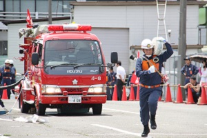 写真：ホースを持って走る団員